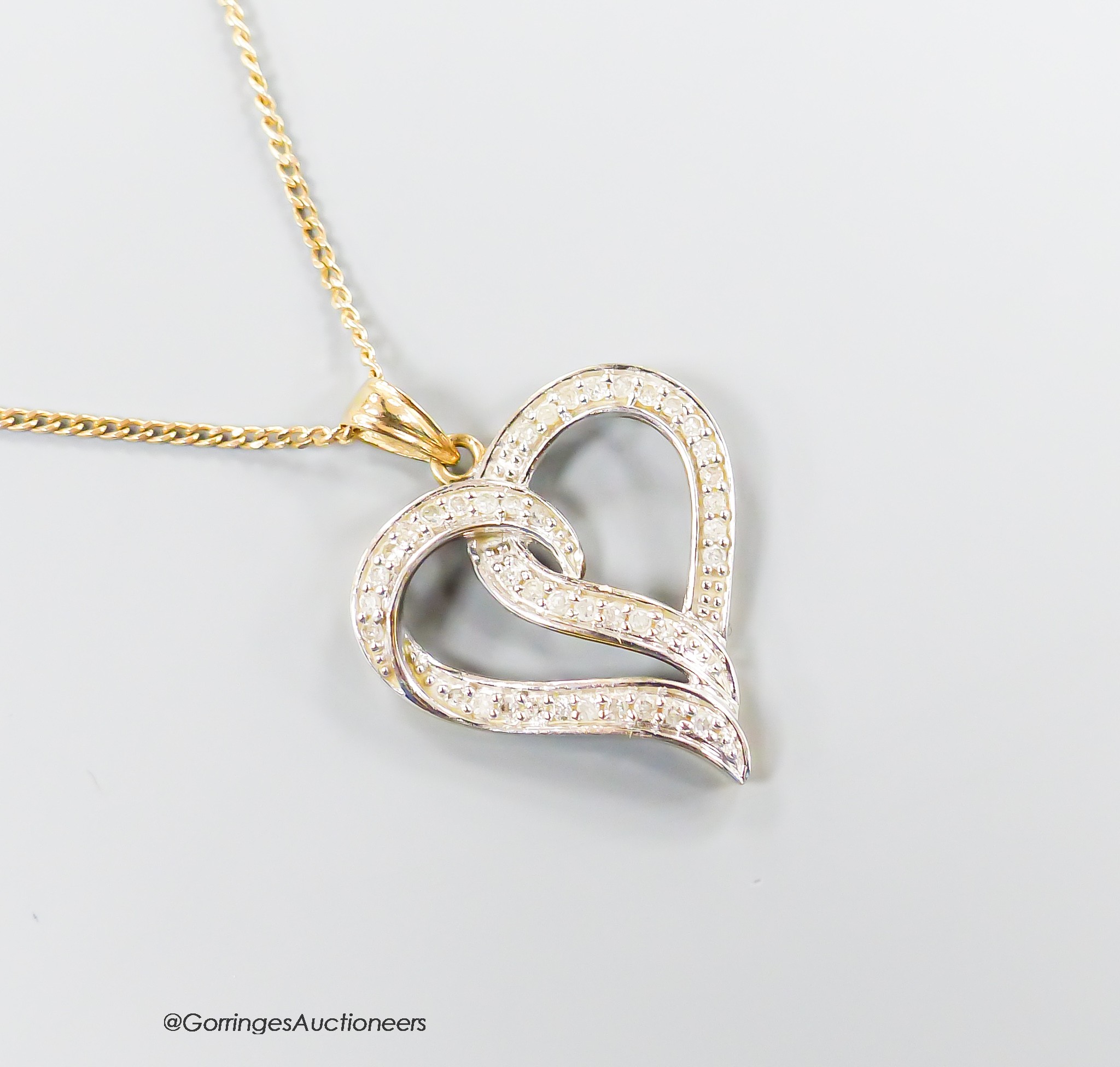 A modern 375 and diamond chip set openwork heart pendant, 22m, on a 9ct gold fine link chain, 46cm, gross weight 3.7 grams.